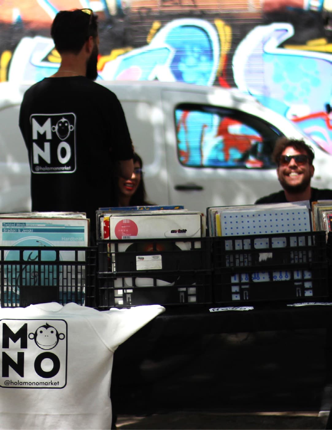 Records in crates on a stand at the Fira, with the Holamonomarket crew behind it