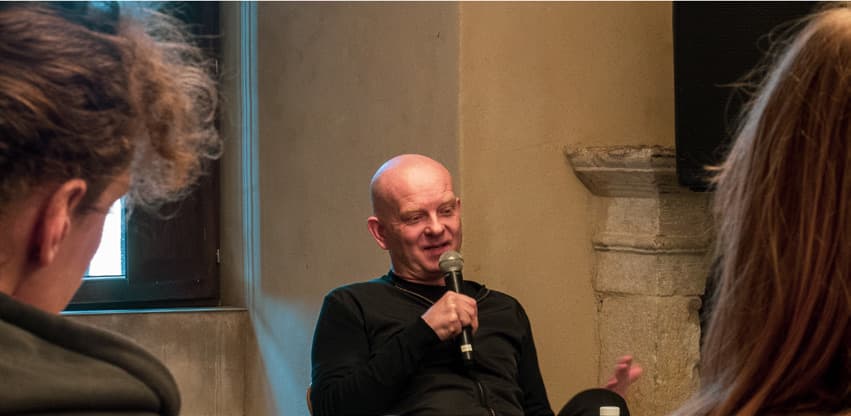Uwe Schmidt speaking into a microphone during the book presentation at the Castell