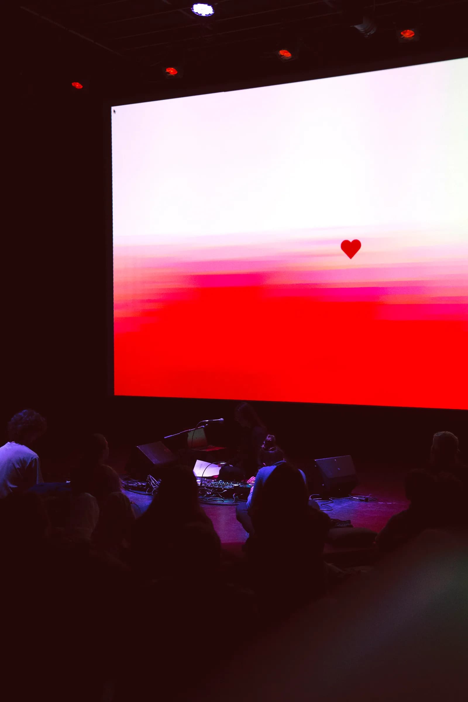Un cor vermell a la pantalla sobre l'escenari, en un concert del país convidat de MOSTRA Barcelona