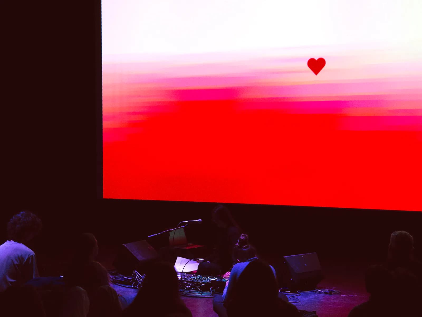 Un cor vermell a la pantalla sobre l'escenari, en un concert del país convidat de MOSTRA Barcelona
